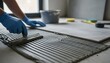 © Bellal - Person in blue gloves spreading adhesive mortar with a notched trowel for floor tiles