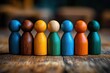 © btiger - Seven colorful wooden peg dolls standing in a row on a textured wooden table, warm lighting and shallow focus conveying togetherness and playful unity