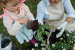 © Halfpoint - High angle view of grandmother with small granddaughter gardening during spring season.
