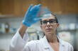 © .shock - Middle Eastern medical technician examining blood slide in clinical lab with focused female doctor