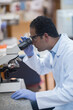 © .shock - Young Middle Eastern medical technician examining blood samples through microscope in clinical laboratory
