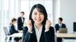 © AiPhoto - オフィスで両手でガッツポーズをして満面の笑みを見せる新卒の女性