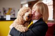 © Виктория Марьенко - Woman embracing fluffy dog in a bright modern office
