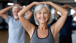 © syhin_stas - Senior woman smiling performing fitness exercises with arm raises in a group fitness class at a retirement home, actively maintaining a healthy and vital lifestyle in older age