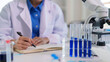 © STBSTD - Adult researcher scientist doctor writing experiment notes laboratory professional conducting scientific analysis medical research innovation