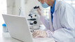 © Pichsakul - Asian adult scientist researcher medical professional performs scientific research experiment analyzes data records findings using technology in modern laboratory