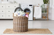 © Pixel-Shot - Basket with laundry on floor near  washing machine
