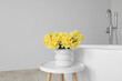 © Pixel-Shot - Beautiful vase with narcissus flowers on coffee table near bathtub in bathroom