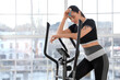 © Pixel-Shot - Sporty young woman with inhaler having asthma attack on exercising bike in gym
