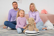 © Pixel-Shot - Happy family with toy bear and robot vacuum cleaner in children's bedroom