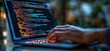 © Mariya - hands typing on a laptop displaying glowing code on screen with warm bokeh background conveying focused concentration