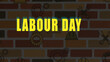 © AbdullahStudio - Labour Day greeting banner with yellow typography, industrial brick wall background with construction icons, worker holiday celebration vector