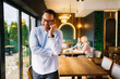 © djile - Businessman talking on smartphone in modern cafe interior