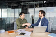 © Liubomir - Two diverse businessmen smiling and shaking hands, finalizing an agreement after a productive meeting in a modern office, representing partnership, success, and professional collaboration