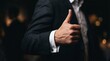 © Candra - Thumbs Up Successful Businessman Hand Gesture on Dark Background.