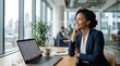 © Cealv - Thoughtful black businesswoman smiling, looking out bright modern office window with city view and laptop.