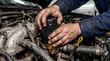 © Razia - Mechanic's hands changing oil filter in a car engine with dirty hands and tools nearby in a garage setting