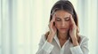 © Nathan - Woman Suffering From Headache in Office Environment with Serious Expression and Focused Stance