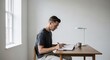 © Lynchsz - Engaged individual focused on writing and creating at a minimalist wooden desk in a bright, tranquil home office, embodying thoughtful work and productive concentration