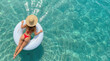 © Mr. Bolota - Woman in a Red Bikini Relaxing on an Inflatable Ring in Crystal Clear Turquoise Ocean Water During a Peaceful Summer Vacation.
