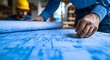 © MiltonKumar - Blueprint review with hands examining architectural floor plan image