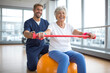 © Crowded Studio - Entrenamiento terapéutico para adultos mayores con bandas de resistencia sobre balón de estabilidad. Un adulto mayor realiza una extensión controlada con banda bajo la guía de un especialista