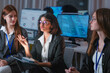 © ultramansk - Confident Indian female AI security expert leading a discussion with colleagues in a dark SOC. Multiethnic women collaborating on threat intelligence and machine learning defense at night.