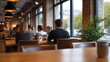 © Bussakon - A group of people collaborating and socializing in a stylish modern cafe filled with natural daylight and greenery