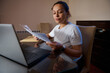 © Taras Grebinets - Woman Reviewing Bills At Laptop In Home Office Paying Finances And Managing Paperwork