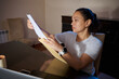 © Taras Grebinets - Woman Reviewing Documents at Home Desk With Envelope and Laptop During Evening Work