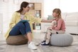© New Africa - Professional psychologist working with little girl on poufs indoors