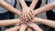 © Studicon - Group of people stacking their hands together, symbolizing teamwork and collaboration