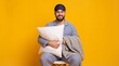 © Firman Dasmir - Man in striped pajamas and eye mask holding a pillow and blanket against a vibrant yellow background
