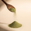 © ColorMint Studio  - Green matcha tea powder being poured from a wooden spoon onto a small pile on a light surface. kelp powder