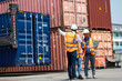 © NVB Stocker - Hispanic man harbor worker talking on the walkie-talkie radio and control loading containers at container warehouse. container yard port of import and export goods