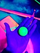 © O-Trism Picture - Hand holding glowing golf ball in blacklight mini golf