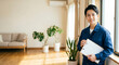 © N.Design 中尾 - Japanese repairman smiling with clipboard and wide copy space in modern living room