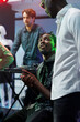 © DC Studio - African american friends chatting while clubbing together in nightclub. Young men talking while resting near stage in club, relaxing at party and enjoying nightlife leisure activity