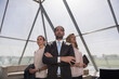 © .shock - Confident business leaders standing together in a modern glass office atrium looking toward the future