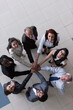 © .shock - Diverse business team standing in a circle with hands joined showing teamwork and unity