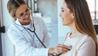© Cyan Creative - Female doctor using stethoscope to examine patient in bright medical office.
