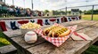 © horizon - Classic American baseball snacks on a weathered picnic table feature two plump hotdogs, buttery popcorn, and a pristine white baseball.