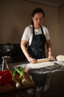 © Taras Grebinets - Woman Rolling Dough With Rolling Pin in Home Kitchen Preparing Homemade Bread