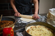 © Taras Grebinets - Homemade Pizza Dough Being Rolled With Rolling Pin in Kitchen Preparation