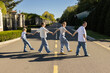 © Anna - happy, freedom-loving family: mother, father, children of different ages, wearing jeans, walk hand in hand across street. Positive emotions, having fun together. Children and parents express joy