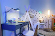 © Pixel-Shot - Interior of children's room with bed, study table and glowing lamps in evening