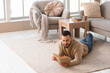 © Pixel-Shot - Handsome young man reading book on floor at home
