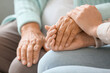 © Pixel-Shot - Senior woman with daughter holding hands at home, closeup