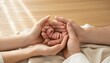© antuanetto - Parents hands cradling a newborn baby with parents for International Day of Families concept representing love protection and unity in a warm home setting