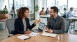 © UnPhouvith - Two business professionals are engaged in a serious discussion at a modern conference table.